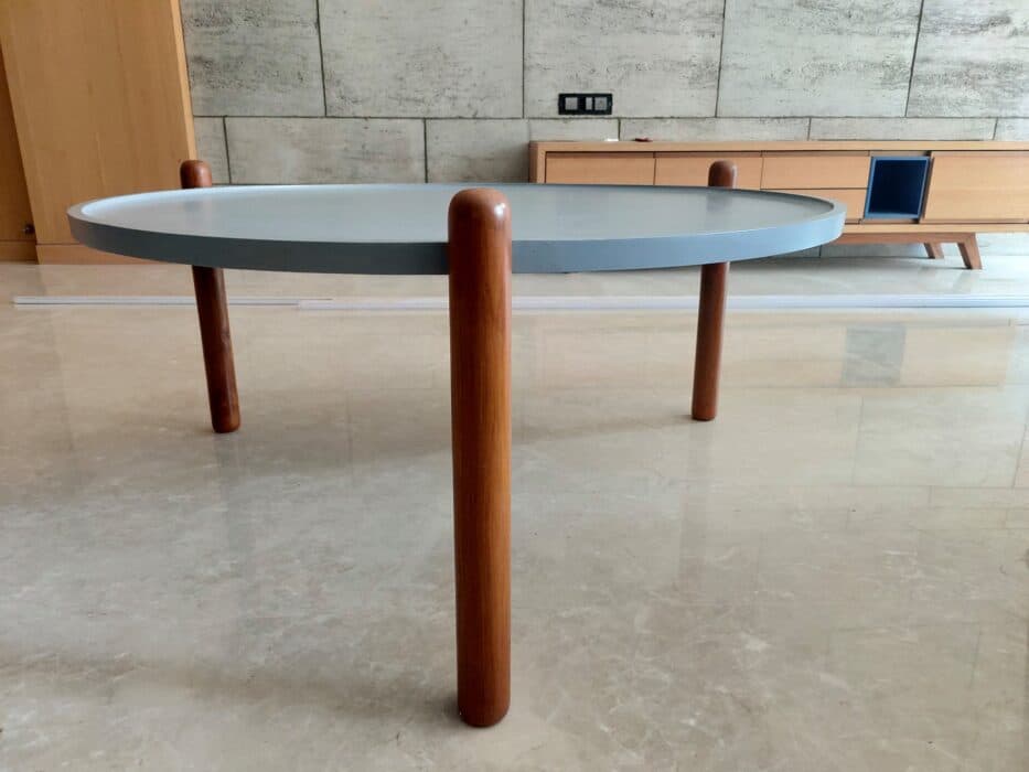 Grey Circular Disc Elegantly Perched on Three Polished Wooden Legs