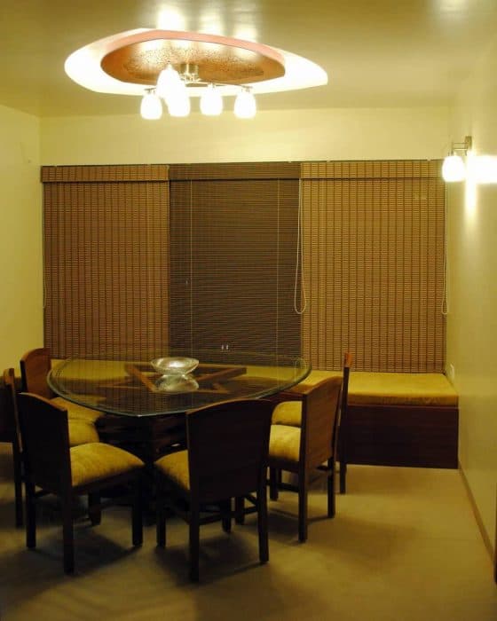 A-Leaf-Shaped-Dining-Table-with-Wooden-Pedestal-Support-Glass-top-Upholstered-Wooden-Dining-Chairs-Long-Seating-under-the-Window.-2 Design Detail Banner 1