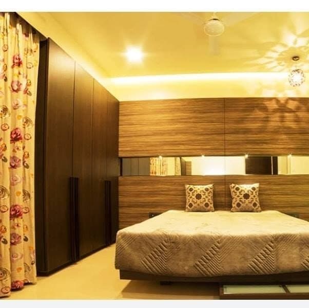 A-Simple-Elegant-Wooden-Concept-is-seen-in-the-Small-Bedroom-in-a-Combination-of-Beige-Brown-Colour-Wooden-Bed-with-a-Backdrop-of-Wooden-Panel-finished-with-a-Laminate Swiper Content 0