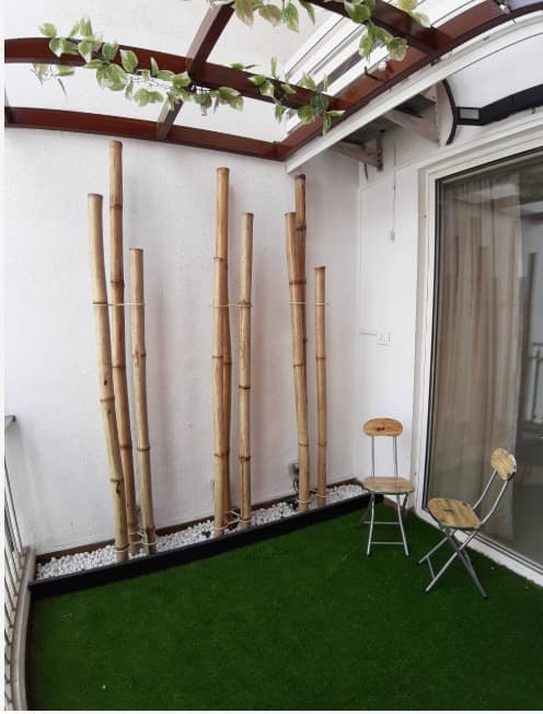 Balcony-designed-with-Artificial-Grass-Mat-on-the-Floor-with-Pedestal-Statue-of-Buddha-in-White-Bamboo-Sticks-on-one-side-over-White-Pebbles-tied-with-a-Thread-4 Balcony-designed-with-Artificial-Grass-Mat-on-the-Floor-with-Pedestal-Statue-of-Buddha-in-White-Bamboo-Sticks-on-one-side-over-White-Pebbles-tied-with-a-Thread