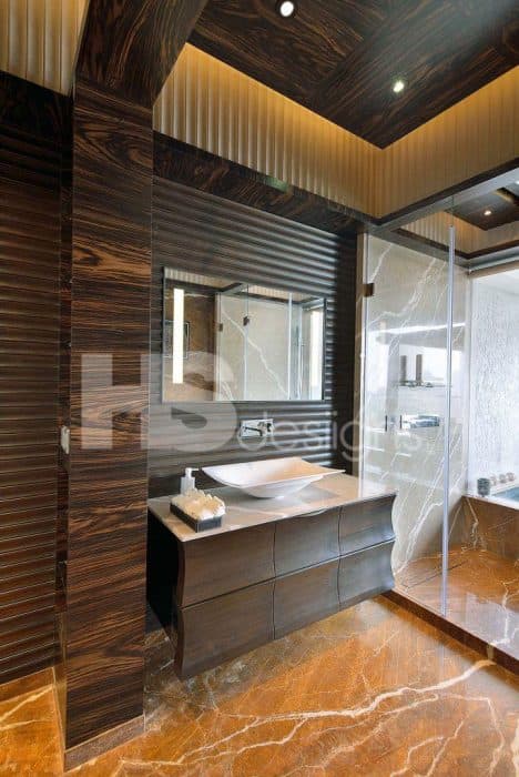 Bathroom-with-Table-Top-Wash-Basin-White-Marble-Counter-top-Wooden-Cabinets-below-the-Counter-Rectangular-Mirror-Shower-Area-separated-by-Glass-Partition-and-Glass-Door Design Detail Banner 0