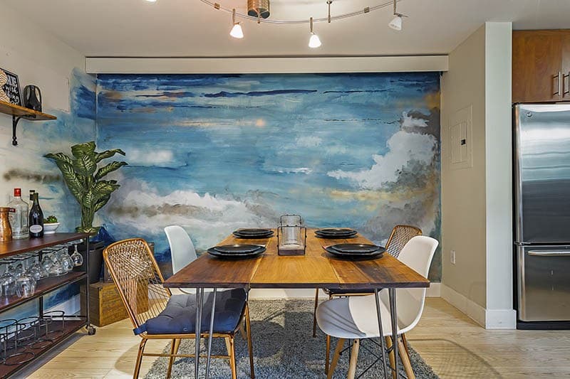 Beach-Theme-Dining-Room-Wall-is-highlighted-with-Ocean-Wave-Painting-Wooden-Flooring-comprises-of-4-Seater-Wooden-Dining-Table-Top-with-Metal-Legs Design Detail Banner 0