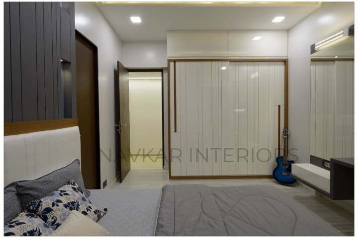 Bedroom-accommodating-Wooden-Double-Bed-with-Storage-below-Cushioned-Wooden-Headboard-Bed-Back-Wall-with-MDF-Wall-Panelling-highlighted-with-Vertical-Grooves-2 Design Detail Banner 1