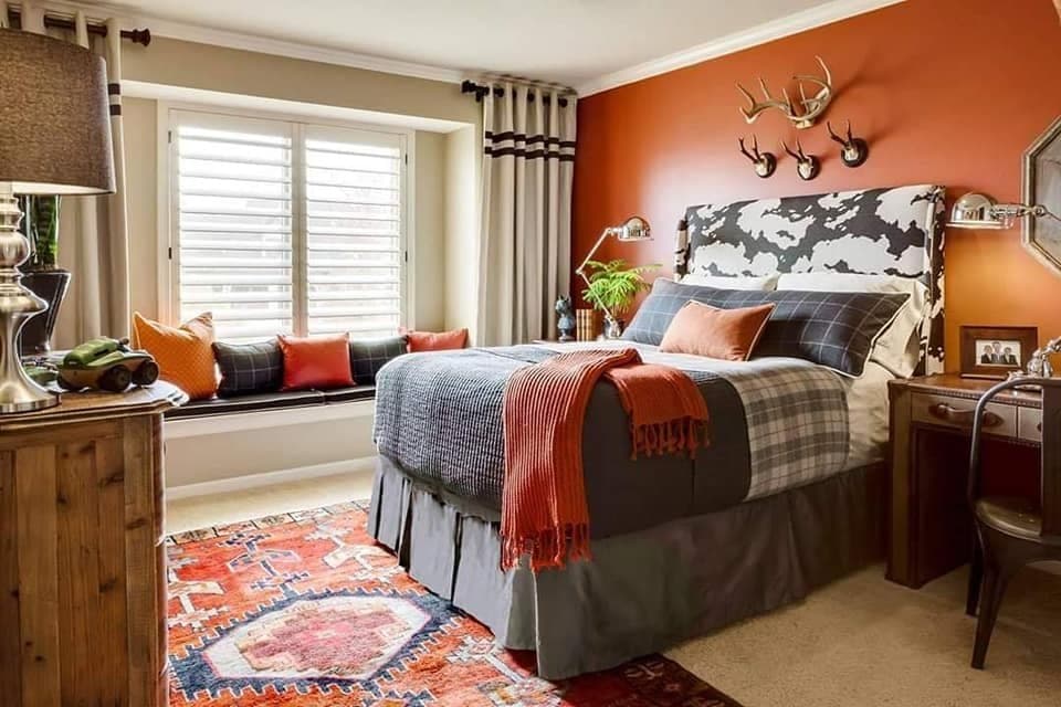 Bedroom-designed-with-Orange-Theme-Highlighted-on-Bed-Back-Wall-Cushions-Throws-Heighted-Bed-with-High-Wingback-Cushioned-Headboard-Study-Table-Window-Nook. Design Detail Banner 0
