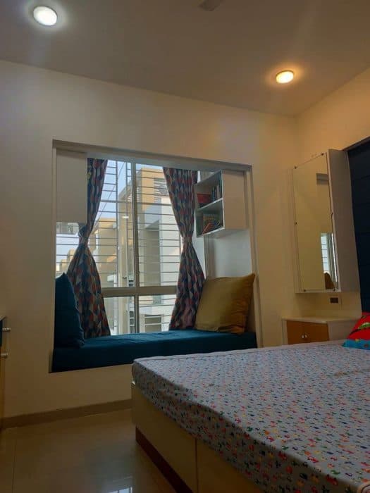 Bedroom-incorporating-Wooden-Double-Bed-with-Storage-Dressing-Table-with-Mirror-Cushioned-Seating-in-front-of-Window-with-Wall-Mounted-Open-Display-Cabinets-above-Study-Table-with-Storage Swiper Content 1