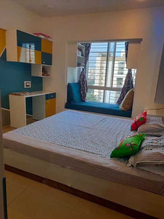 Bedroom-incorporating-Wooden-Double-Bed-with-Storage-Dressing-Table-with-Mirror-Cushioned-Seating-in-front-of-Window-with-Wall-Mounted-Open-Display-Cabinets-above-Study-Table-with-Storage. Swiper Content 0