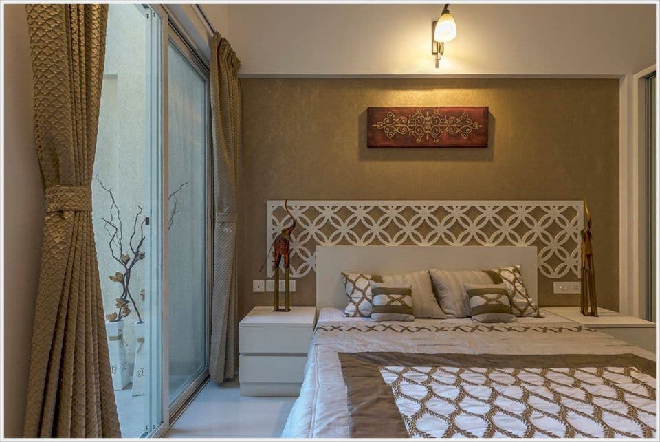 Bedroom-with-Wooden-Double-Bed-Wooden-Headboard-Floor-Mounted-Wooden-Side-Tables-with-Antiques-Bed-Back-Wall-highlighted-with-Wallpaper Design Detail Banner 1