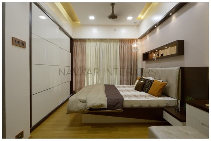 Bedroom-with-Wooden-Flooring-comprises-of-Wooden-Double-Bed-with-Storage-below-Wall-Mounted-Wooden-Side-Table-Bed-Back-Wall-with-Niche-highlighted-with-Spot-Lights-1 Design Detail Banner 0