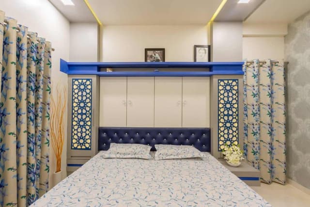 Blue-Themed-Bedroom-with-Wooden-Double-Bed-with-Round-Corners-Button-Tufted-Chesterfield-Upholstered-Headboard-Bed-Back-Wall-with-Built-in-Storage-Cabinet Swiper Content 1