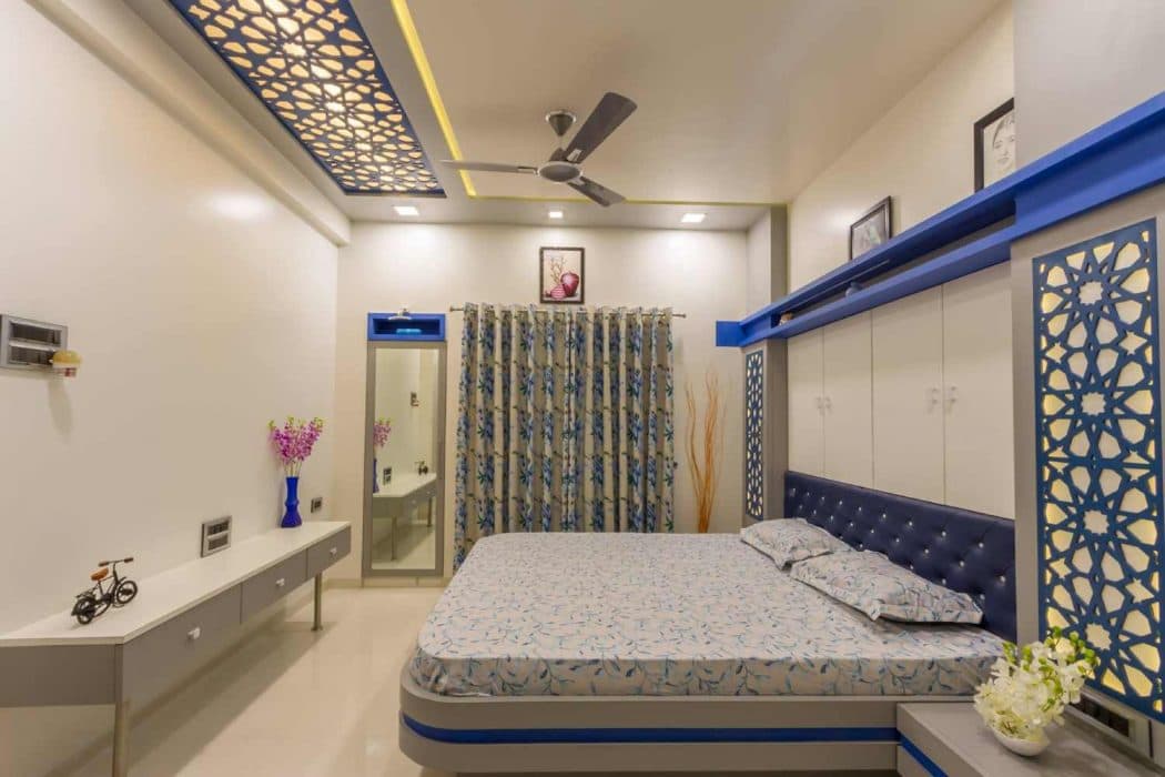 Blue-Themed-Bedroom-with-Wooden-Double-Bed-with-Round-Corners-Button-Tufted-Chesterfield-Upholstered-Headboard-Bed-Back-Wall-with-Built-in-Storage-Cabinet. Design Detail Banner 0