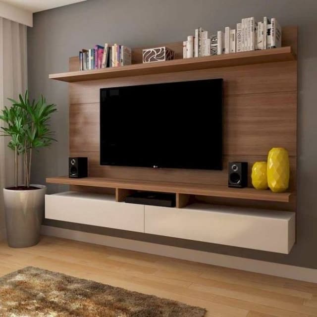 Brown-Coloured-Wooden-TV-Unit-with-Groves-a-Long-Pull-Out-Drawers-with-White-Finishes-with-Floating-Shelves-which-acts-as-a-Book-Stand. Swiper Content 0