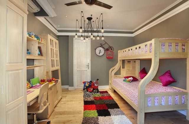 Childrens-Bedroom-with-Wooden-Flooring-comprises-of-Wooden-Bunk-Bed-Colourful-Rug-Wooden-Study-Table-with-Wall-Mounted-Shelves-Open-Display-Cabinet-for-Storage Swiper Content 0