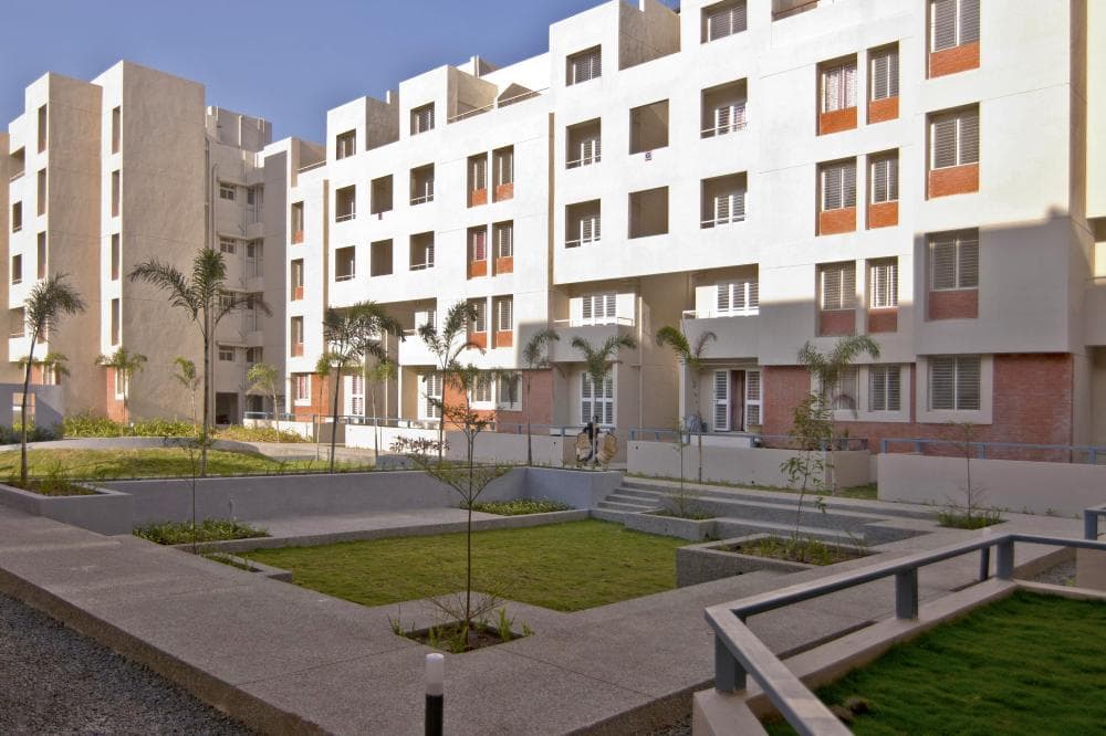 Cluster-of-5-Storeyed-Apartment-Buildings-with-Lush-Green-Lawn-in-the-center-Concrete-Pathway-leading-to-Gardens-2 Design Detail Banner 1