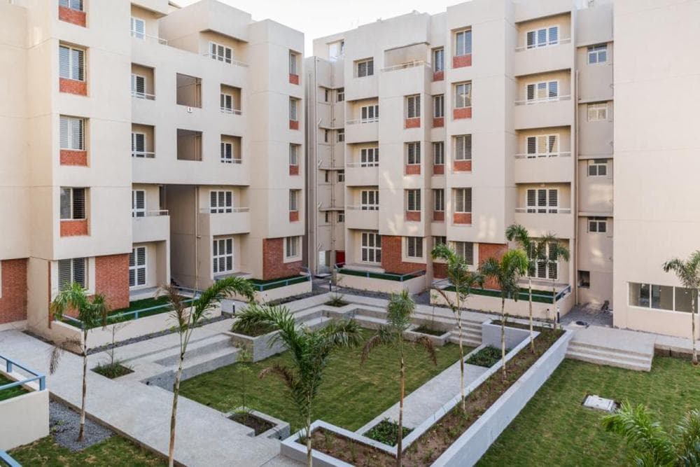 Cluster-of-5-Storeyed-Apartment-Buildings-with-Lush-Green-Lawn-in-the-center-Concrete-Pathway-leading-to-Gardens-5 Design Detail Banner 4