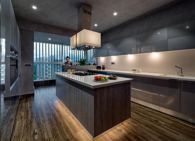 Contemporary-L-Shaped-Kitchen-with-Peninsula-Kitchen-Island-in-Grey-White-Colour-Built-in-Stove-on-Island-with-Center-Chimney-with-Warm-Lights-1 Swiper Content 0