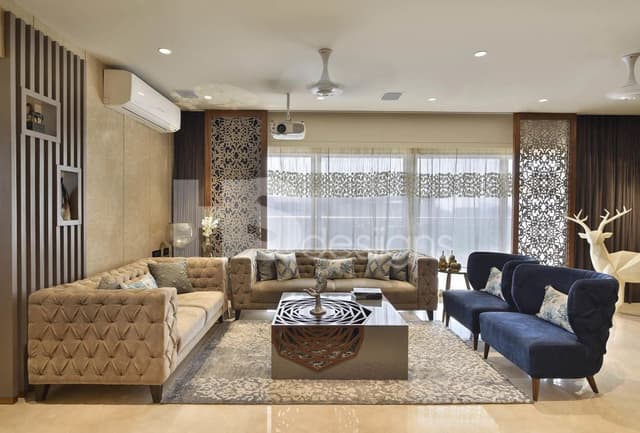 Contemporary-Living-Room-consisting-Tuxedo-Sofa-Set-Navy-Blue-Coloured-Wingback-Chairs-with-Low-Back-a-Unique-designed-Coffee-Table-with-Antique-Books-placed-on-it Swiper Content 0