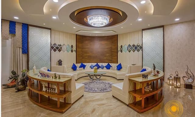 Contemporary-Living-Room-designed-with-Circular-Shaped-Sofa-with-Wooden-Shelves-behind-the-Sofa Swiper Content 0