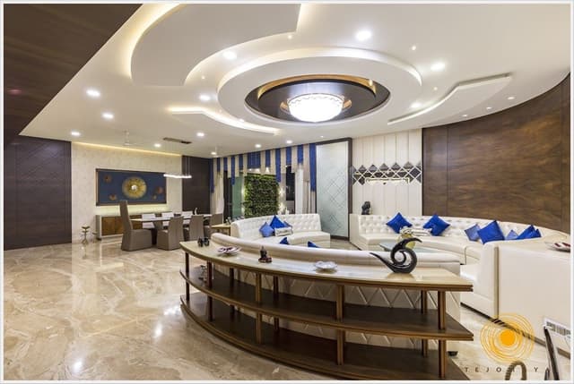 Contemporary-Living-Room-designed-with-Circular-Shaped-Sofa-with-Wooden-Shelves-behind-the-Sofa. Swiper Content 1