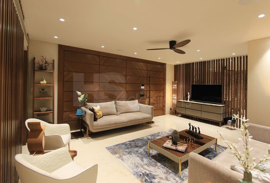 Contemporary-Living-Room-incorporating-Sofa-Set-Coffee-Table-over-a-Rug-End-Tables-with-Flower-Vases-T.V.-Unit-with-Wooden-Slits-behind-Free-Standing-Shelves-for-keeping-Antiques-Books. Design Detail Banner 0