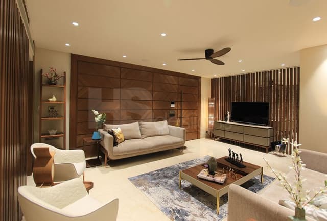 Contemporary-Living-Room-incorporating-Sofa-Set-Coffee-Table-over-a-Rug-End-Tables-with-Flower-Vases-T.V.-Unit-with-Wooden-Slits-behind-Free-Standing-Shelves-for-keeping-Antiques-Books. Swiper Content 0