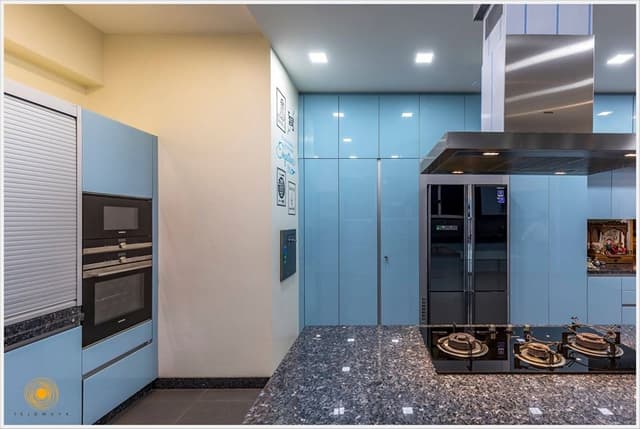 Contemporary-Styled-Light-Blue-Coloured-Island-Kitchen-comprises-of-L-Shaped-Kitchen-Counter-with-Dark-Grey-Shaded-Grained-Kitchen-Countertop-2 Swiper Content 1