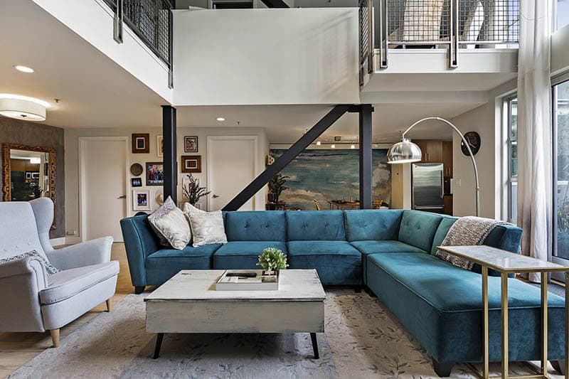 Double-Heighted-Living-Room-with-Glazed-Facade-Wooden-Flooring-comprises-of-Sea-Blue-Velvet-Fabric-Upholstered-Sectional-Sofa-with-Right-Facing-Chaise.-1 Design Detail Banner 2
