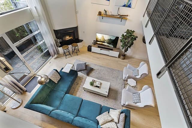 Double-Heighted-Living-Room-with-Glazed-Facade-Wooden-Flooring-comprises-of-Sea-Blue-Velvet-Fabric-Upholstered-Sectional-Sofa-with-Right-Facing-Chaise. Swiper Content 0