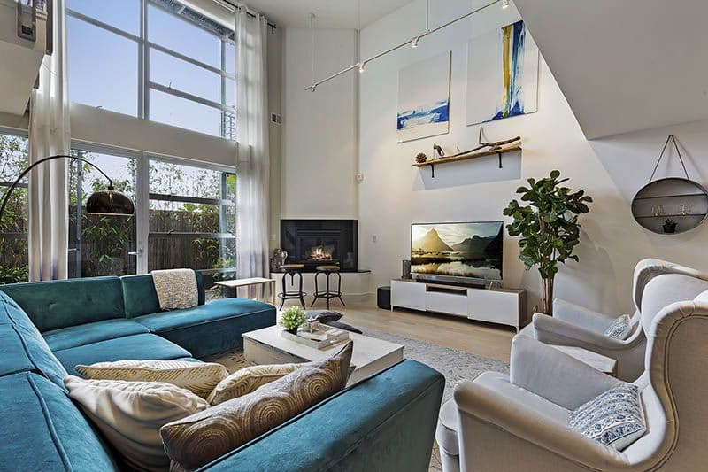 Double-Heighted-Living-Room-with-Glazed-Facade-Wooden-Flooring-comprises-of-Sea-Blue-Velvet-Fabric-Upholstered-Sectional-Sofa-with-Right-Facing-Chaise Design Detail Banner 1