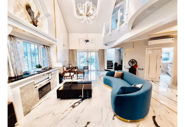 Double-Heighted-Living-Room-with-Marble-Flooring-highlighted-with-Metal-Strip-Inlay-Light-Blue-Low-Back-Upholstered-Sofa-with-Golden-Metal-Base. Swiper Content 0