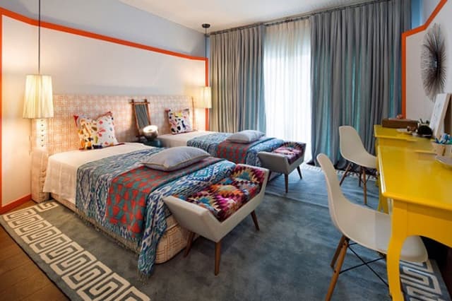 Elegant-Bedroom-with-Wooden-Flooring-adorned-with-Grey-Rug-accommodates-Fabric-Upholstered-Single-Beds Swiper Content 0