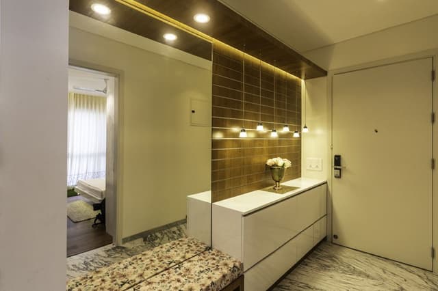 Entrance-Foyer-incorporating-Wall-Mounted-Mirror-Wooden-Wall-Panelling-highlighted-with-Grooves-continuing-in-Ceiling-with-Recessed-Hanging-Pendant-Light-1 Swiper Content 0