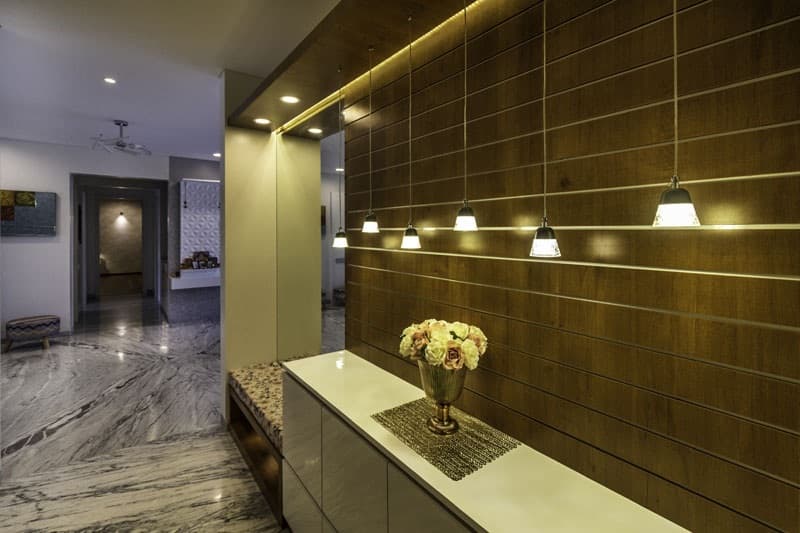 Entrance-Foyer-incorporating-Wall-Mounted-Mirror-Wooden-Wall-Panelling-highlighted-with-Grooves-continuing-in-Ceiling-with-Recessed-Hanging-Pendant-Light-2-1 Design Detail Banner 1