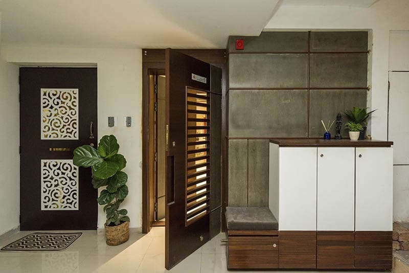Entrance-Wooden-Jali-Door-surrounded-by-Wooden-Wall-Panelling-Textured-Cladding Design Detail Banner 0