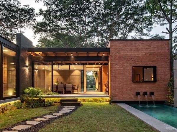 Exterior-View-of-Backyard-of-Single-Floor-Bungalow-with-Glass-Facade-one-of-its-Wall-highlighted-with-Exposed-Brick-Wall-with-Sliding-Window-incorporating-Waterfall-Wall-Feature Design Detail Banner 0