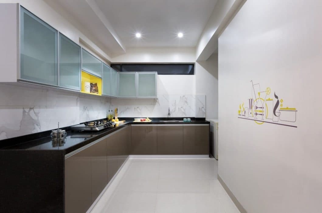 L-Shaped-Modular-Kitchen-with-Black-Granite-Countertops-Lower-Cabinets-with-Aluminum-Profile-Handles-Upper-Cabinets-with-Glass-Shutters-with-a-Highlighter-Yellow-Coloured-Open-display-Box Design Detail Banner 0
