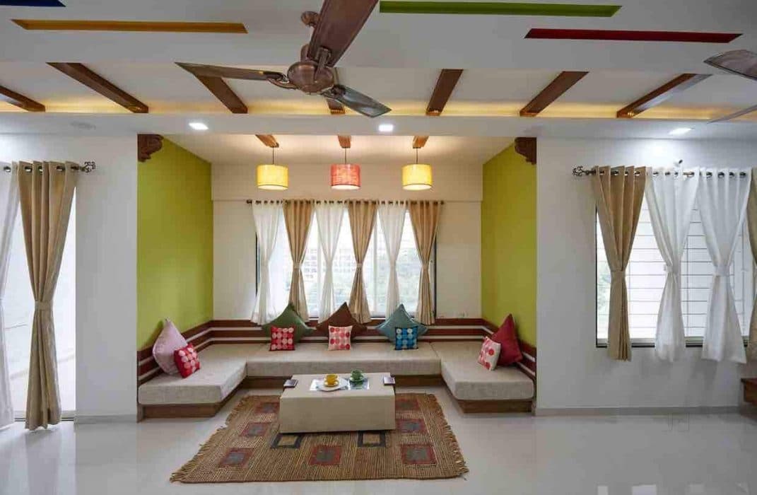 Living-Room-accommodating-C-Shaped-Low-Heighted-Sofa-with-Colourful-Cushions-Coffee-Table-placed-on-a-Rug-T.V.-Unit-Sofa-Chairs-with-attached-Storage-Unit-Hanging-Pendant-Lights Design Detail Banner 1