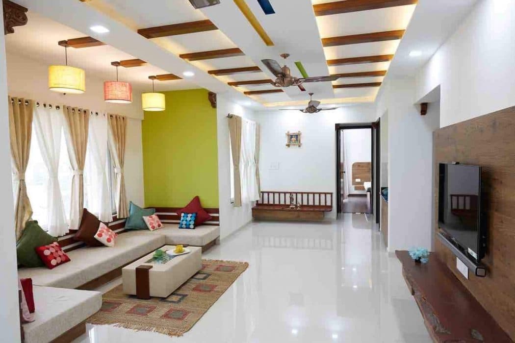 Living-Room-accommodating-C-Shaped-Low-Heighted-Sofa-with-Colourful-Cushions-Coffee-Table-placed-on-a-Rug-T.V.-Unit-Sofa-with-attached-Storage-Unit-Hanging-Pendant-Lights. Design Detail Banner 2