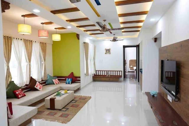 Living-Room-accommodating-C-Shaped-Low-Heighted-Sofa-with-Colourful-Cushions-Coffee-Table-placed-on-a-Rug-T.V.-Unit-Sofa-with-attached-Storage-Unit-Hanging-Pendant-Lights. Swiper Content 2