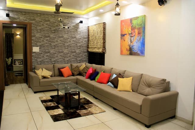 Living-Room-designed-with-Beige-Coloured-Curved-Armed-L-Shaped-Sectional-Sofa-with-Colourful-Cushions Swiper Content 0