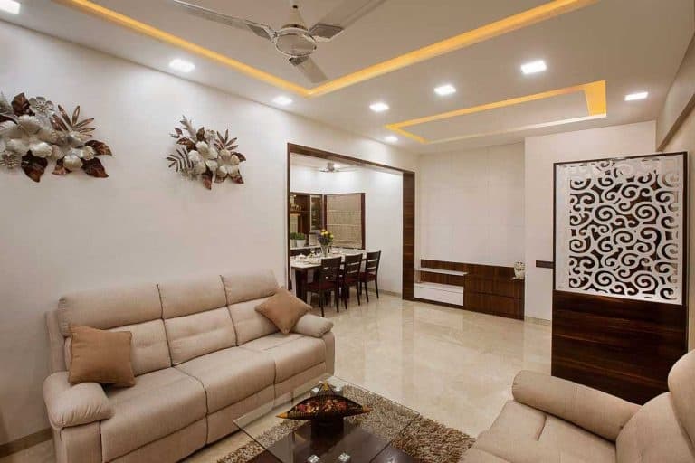 Living-Room-designed-with-Cream-Beige-Theme-incorporating-Leather-Upholstered-Recliner-Sofa-Set-Glazed-Coffee-Table-placed-on-a-Rug-Side-Table-with-a-Flower-Vase-placed-on-it-TV-unit.. Design Detail Banner 1