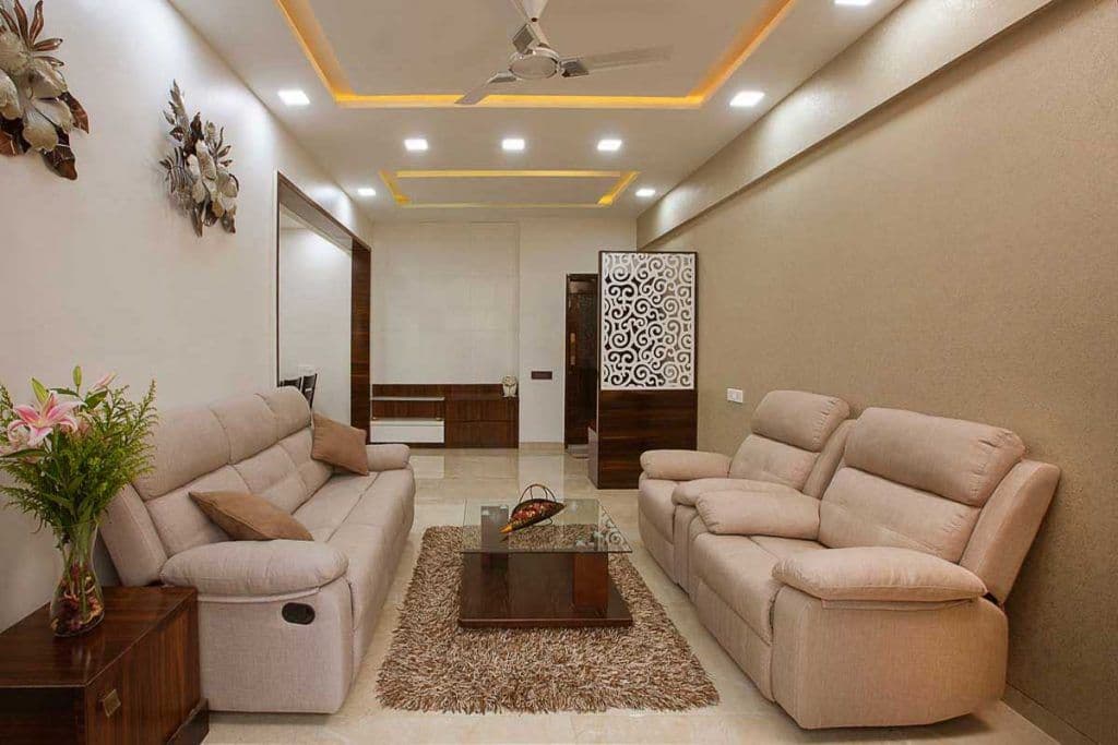 Living-Room-designed-with-Cream-Beige-Theme-incorporating-Leather-Upholstered-Recliner-Sofa-Set-Glazed-Coffee-Table-placed-on-a-Rug-Side-Table-with-a-Flower-Vase-placed-on-it-TV-unit. Design Detail Banner 0