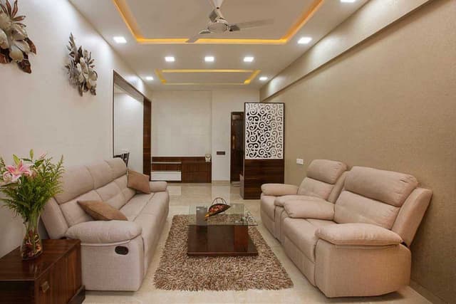 Living-Room-designed-with-Cream-Beige-Theme-incorporating-Leather-Upholstered-Recliner-Sofa-Set-Glazed-Coffee-Table-placed-on-a-Rug-Side-Table-with-a-Flower-Vase-placed-on-it-TV-unit. Swiper Content 0