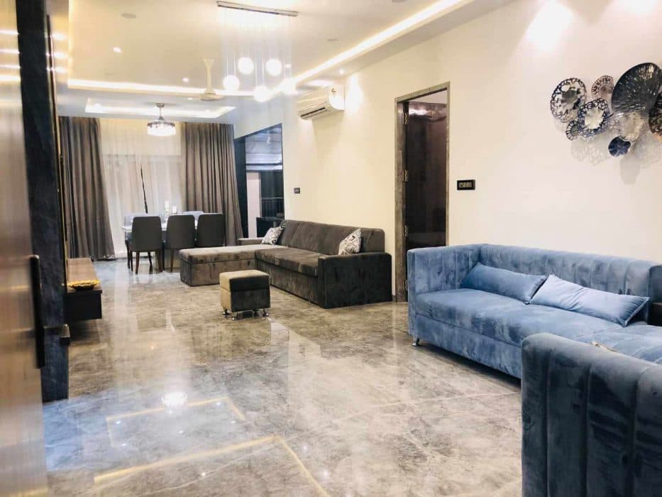 Living-Room-designed-with-Formal-Informal-rooms-accommodating-Velvet-upholstered-Grey-Coloured-Square-Armed-Modern-Sectional-Tuxedo-Style-Sofa-1 Design Detail Banner 0