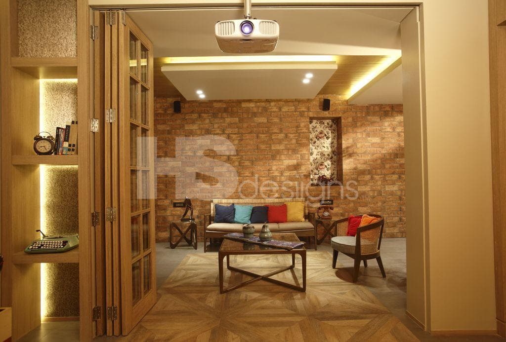 Living-Room-in-Rustic-Theme-accommodating-Wooden-cum-Wicker-Sofa-Set-with-Colourful-Cushions-Wooden-Coffee-Table-with-Glass-top-Half-Round-Chairs-Projector-Built-in-Wall-Shelves. Design Detail Banner 1