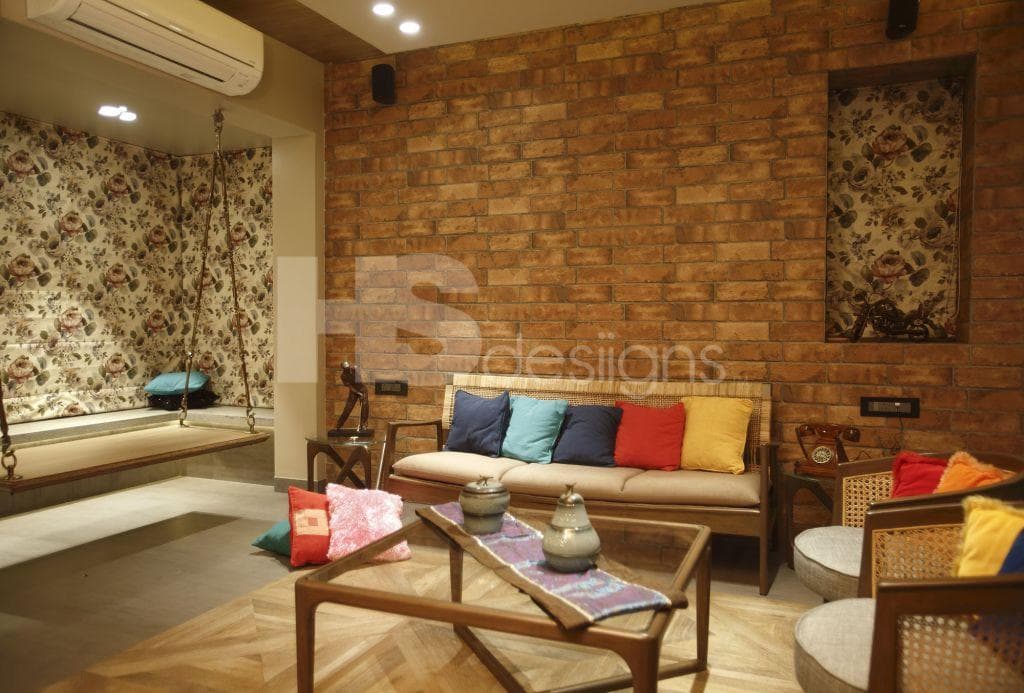 Living-Room-in-Rustic-Theme-accommodating-Wooden-cum-Wicker-Sofa-Set-with-Colourful-Cushions-Wooden-Coffee-Table-with-Glass-top-Half-Round-Chairs-Projector-Built-in-Wall-Shelves Design Detail Banner 0