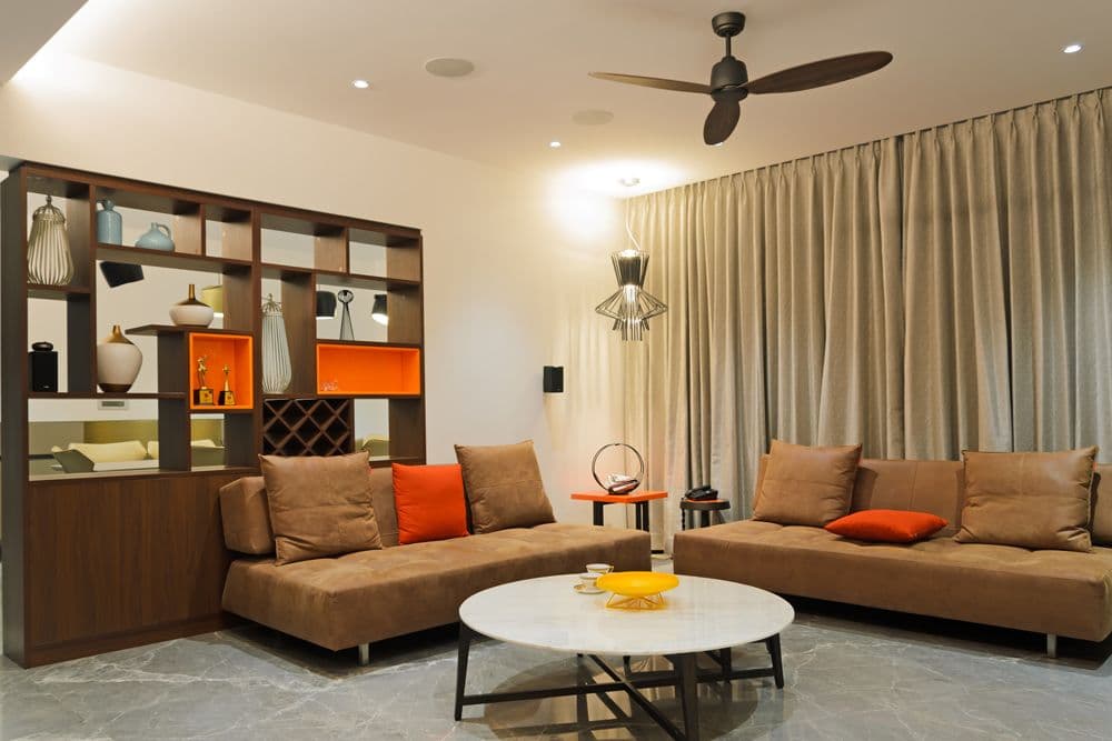 Living-Room-incorporating-Upholstered-Armless-Sofas-with-Sofa-Cushions-Circular-Center-Table-Circular-Side-Tables-Wooden-Partition-with-Open-Shelves-2 Design Detail Banner 1