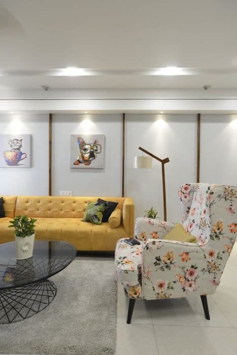 Living-Room-incorporating-Yellow-Coloured-Square-Armed-L-Shaped-Sectional-Sofa-with-Left-Facing-Chaise-Floral-Fabric-Upholstered-Wing-Chair-with-High-Back-2 Design Detail Banner 1