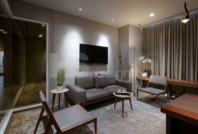 Living-Room-with-Central-AC-System-consists-of-Grey-Cushioned-Sofa-Cushioned-Single-Sofa-Chairs-Floor-Lamp-Side-Tables-with-Wooden-Tripod-Base-with-Indoor-Plant Swiper Content 0