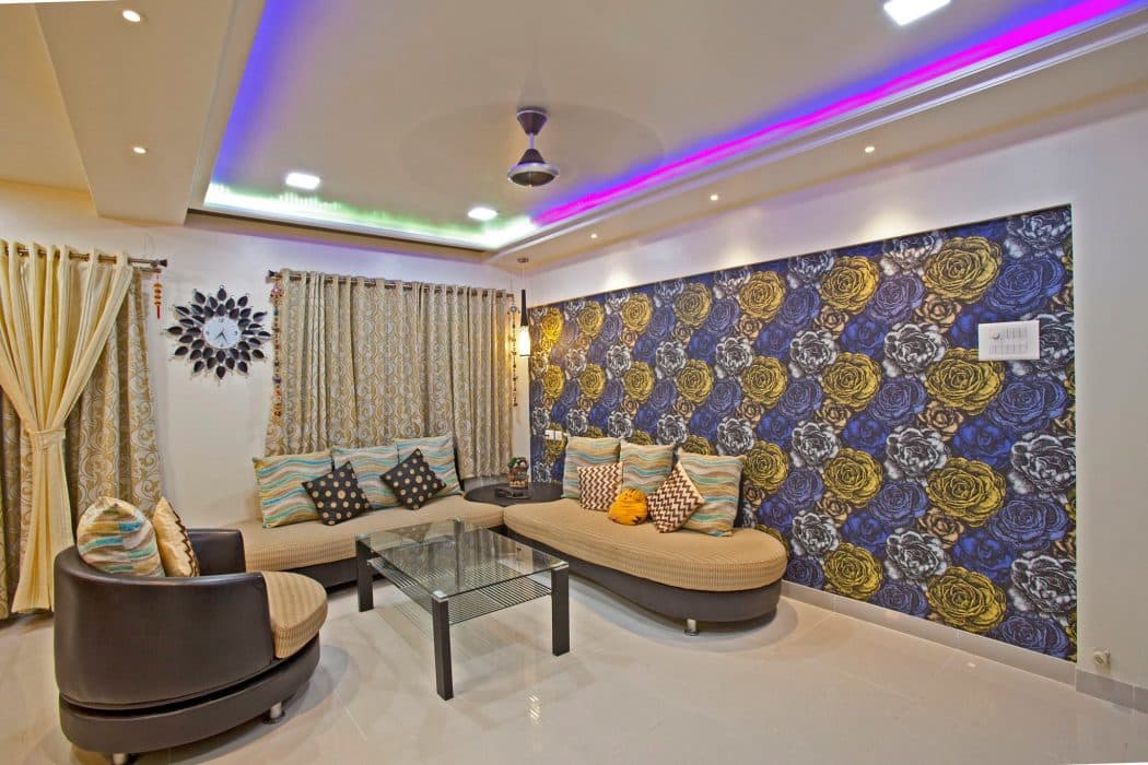 Living-Room-with-Round-Edge-L-Shaped-Backless-Seating-with-Large-Cushions-wooden-Coffee-Table-with-Glass-top-Shelf Design Detail Banner 0