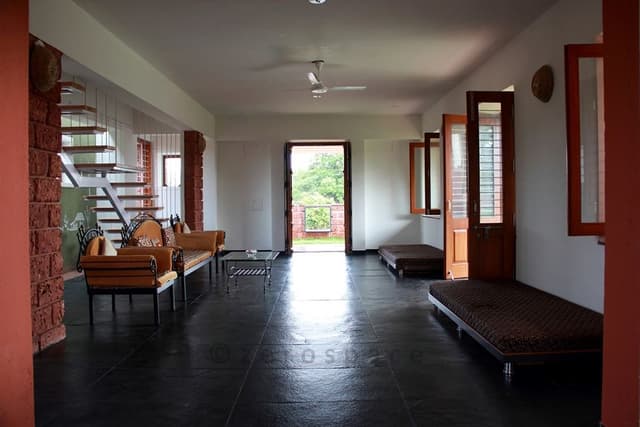 Living-Room-with-Solid-Black-Textured-Flooring-comprises-of-Traditional-Metal-Frame-Sofa-with-Sofa-Cushions-Cushioned-Rolled-Arms Swiper Content 0
